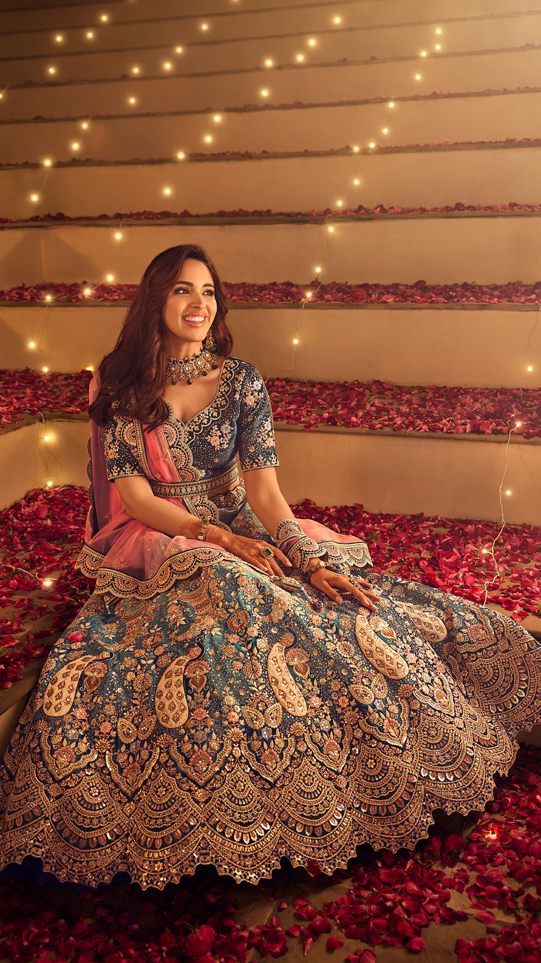 A bride wearing a royal blue velvet lehenga adorned with intricate golden designs, exuding regal charm.